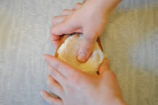 Spreading the kahk dough into the mold ahead of filling it.