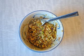 Bowl of orange blossom water and chopped pistachios filling for Kahk.