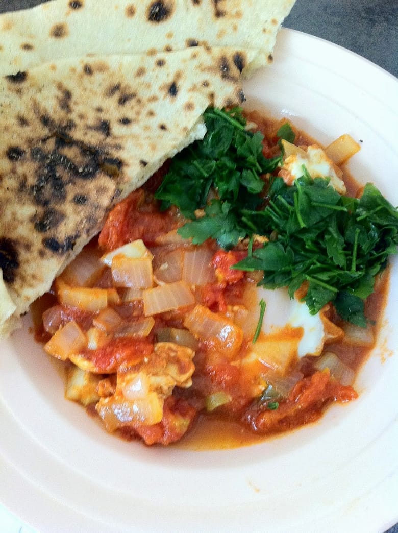 Shakshuka (poached eggs) served with haish baladi (country pita bread)